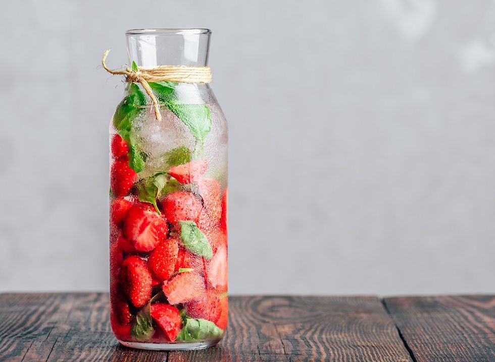 Despeje água com morangos e manjericão