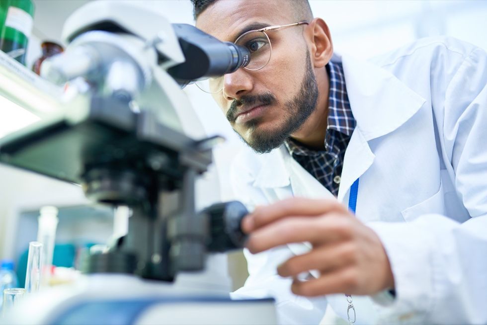 Cientista em laboratório usando microscópio
