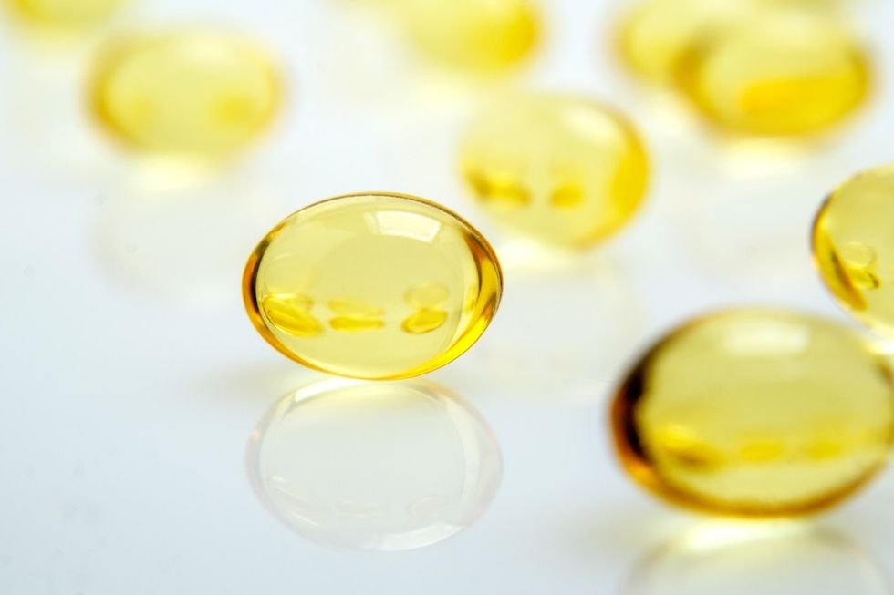 Suplemento de óleo de fígado de bacalhau em fundo branco